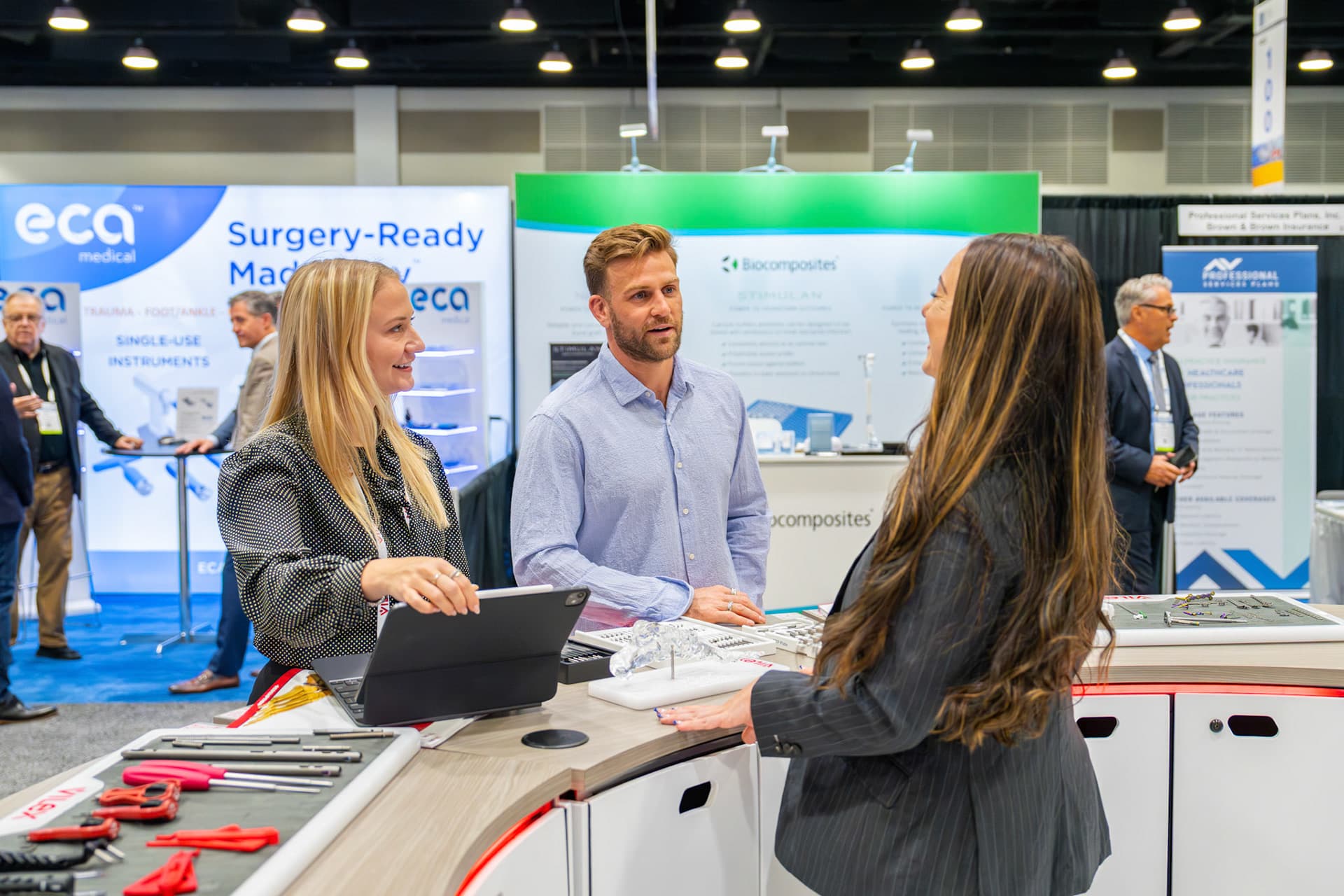 Conversations at a booth on the AOFAS 2024 exhibit hall floor.