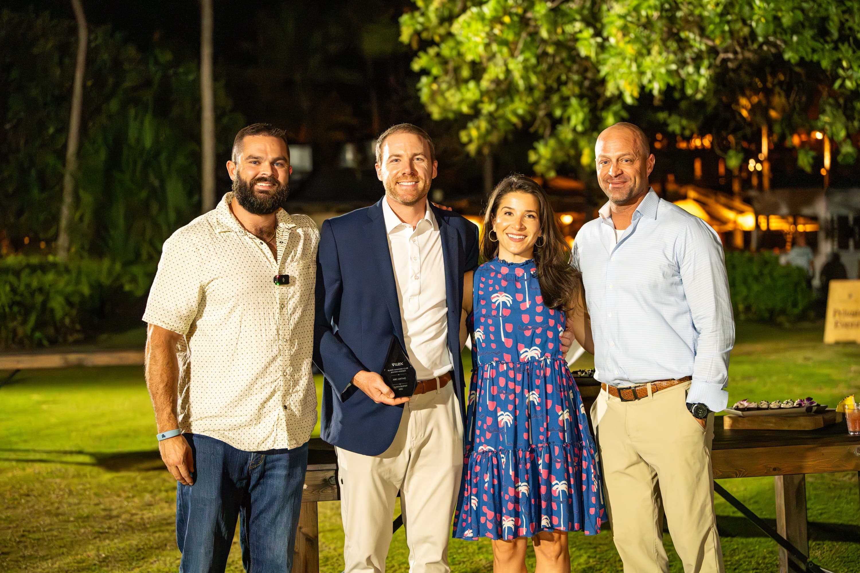Four guests pose together outdoors at dusk at the 2024 Black Diamond Club.